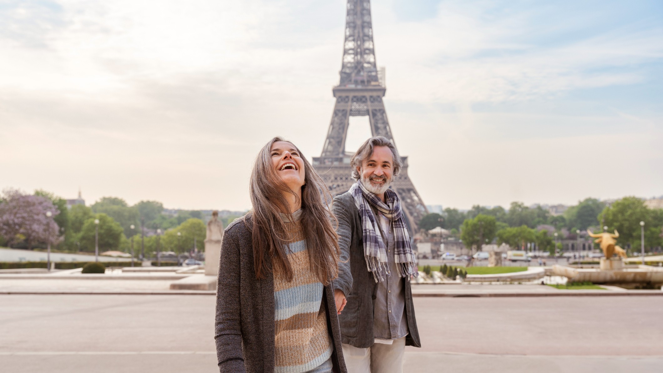 A happy mature couple enjoying a vacation in front of the Eiffel Tower.