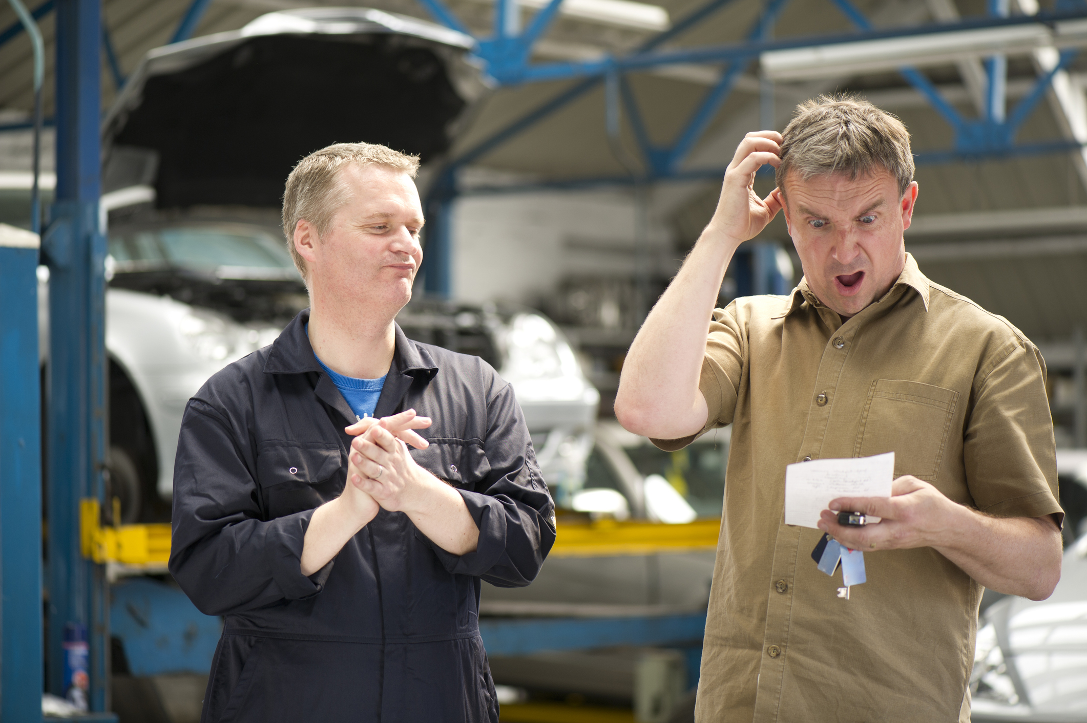 A concerned driver looking at a high auto repair invoice.
