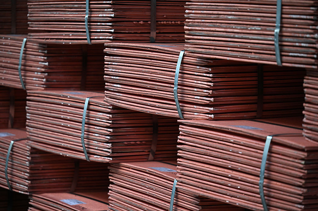 Stacks of refined copper cathode sheets in a smelting facility.