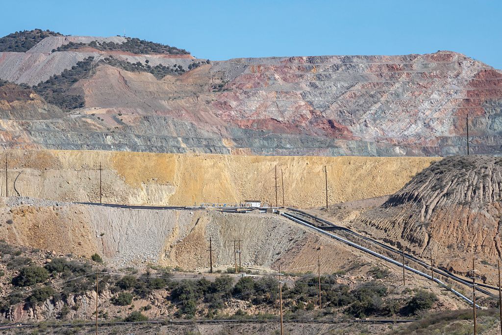 An aerial view of a large-scale open-pit copper mine.