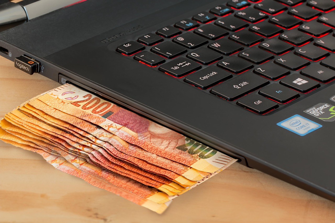 A person using a laptop for online banking to check enrollment status